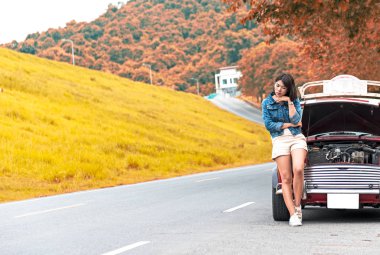 Yardım'ı sokakta kırık aşağı araba bekleyen genç kadın. Vintage sesi.