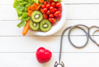 Diyet ve kilo kaybı ile sağlık stetoskop, fitness ekipmanları, sebze salatası ve eski Beyaz ahşap arka plan üstten görünüm üzerinde kırmızı kalp sağlıklı gıda sağlıklı bakımı için. Sağlıklı kavramı.