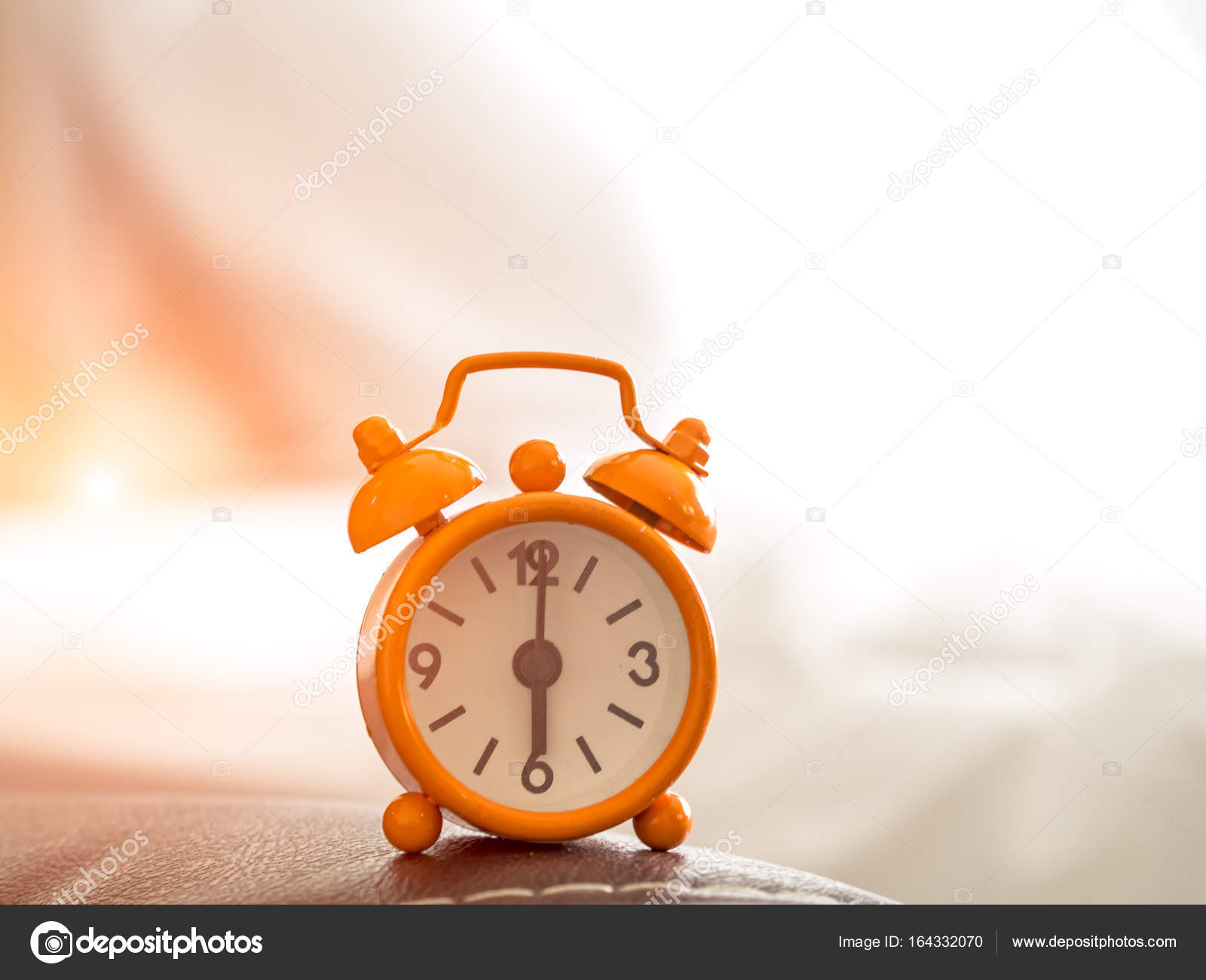 Reloj despertador naranja en la cama por la mañana con luz solar:  fotografía de stock © Freebird7977 #164332070