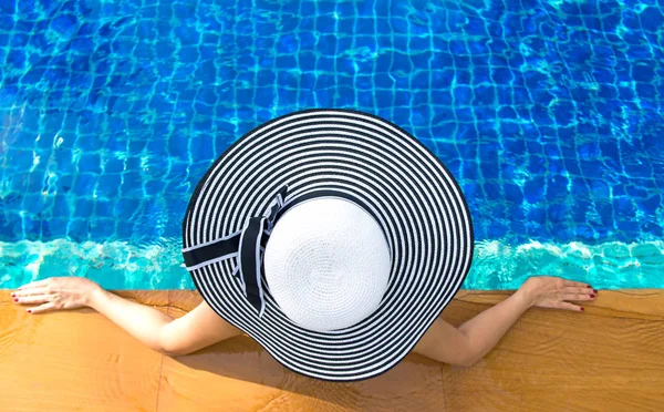 Mulheres chapéu grande estilo de vida relaxante perto de banho de sol piscina de luxo, dia de verão no resort de praia no hotel. Conceito de Verão — Fotografia de Stock