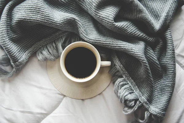 Gemütliche Winter-Home-Hintergrund, Tasse heißen Kaffee mit Marshmallow, warme Strickpullover auf weißem Betthintergrund, Vintage-Ton. Lifestylekonzept — Stockfoto
