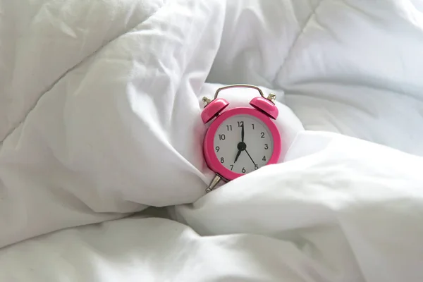 태양 빛으로 아침에 침대에 6 오 시계 핑크 알람 시계에 의하여 일어나 있었다. 라이프 스타일 개념 — 스톡 사진