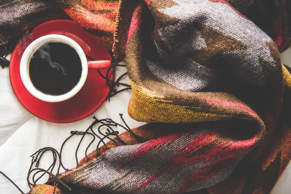 Acogedor fondo de la casa de invierno, taza de café caliente con malvavisco, suéter de punto cálido sobre fondo de cama blanca, tono vintage. Concepto de estilo de vida — Foto de Stock