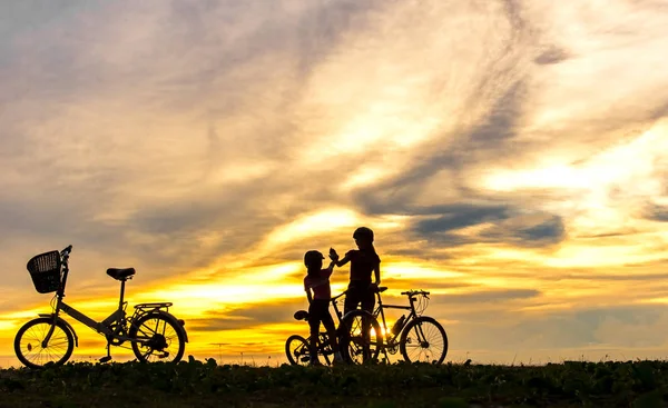 바다 위에 석양 실루엣 자전거 사랑 스러운 가족. 엄마와 딸 해변에서 자전거 라이프 스타일 개념. — 스톡 사진
