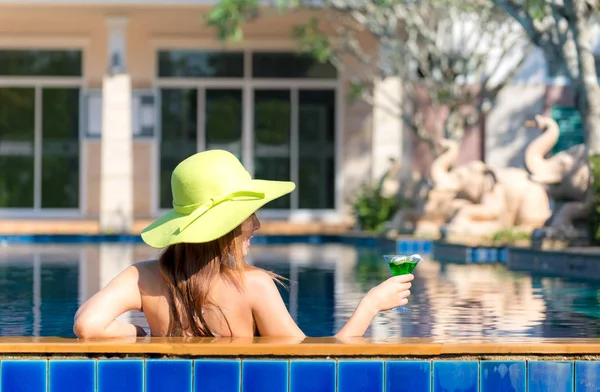 Estilo de vida asiático Mulher em maiô relaxante e feliz com coquetel em chaise-longue perto da piscina, dia de verão. Conceito de Verão . — Fotografia de Stock