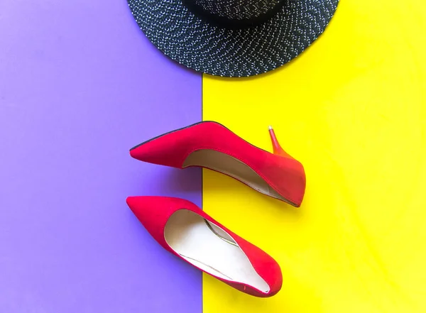 Mode femme accessoires ensemble. Mode à la mode chaussures rouges talons, élégant grand chapeau. Fond violet et jaune coloré. Concept de style de vie — Photo