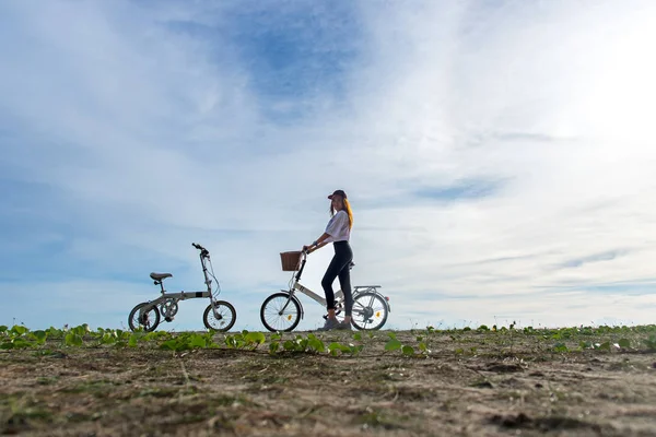 웃는 여자 즐길와 재미 있고 행복 한, 푸른 하늘 배경 해변 모래를 타고 자전거 함께 휴식. 라이프 스타일 개념. — 스톡 사진
