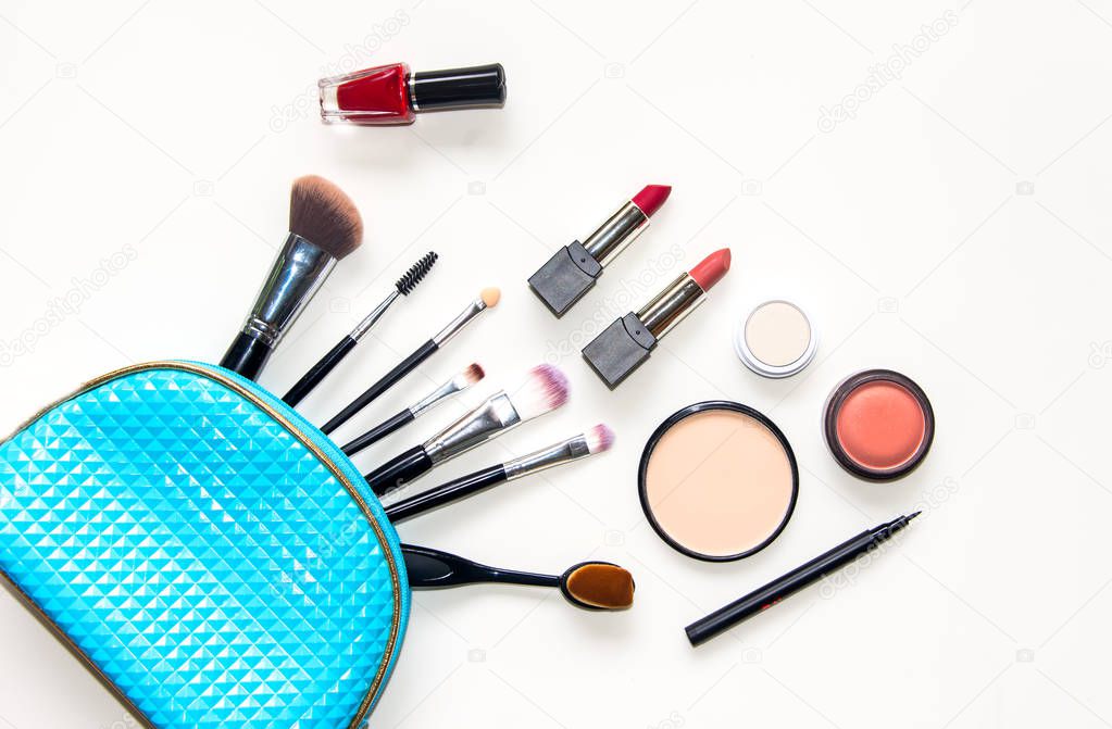 Cosmetics and fashion background with make up artist objects: lipstick, eye shadows, mascara ,eyeliner, concealer, nail polish with blue bag cosmetic.  Lifestyle Concept