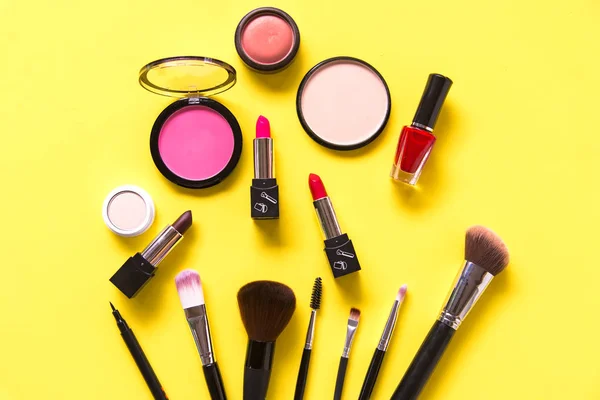 Cosméticos e fundo de moda com compõem objetos do artista: batom, sombras de olhos, rímel, delineador, corretor, esmalte de unhas, fundo colorido amarelo. Conceito de Estilo de Vida — Fotografia de Stock