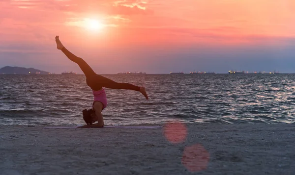 Silhouette jeune femme style de vie exercice vital méditer et pratiquer le yoga sur la plage au coucher du soleil. Concept sain — Photo