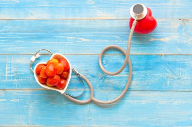 Bir tek tek başına kırmızı kalp aşk şekli el egzersiz topu bandaj Md Medikal ile doktor doktor stetoskop mavi ahşap arka plan. Sağlıklı kavramı