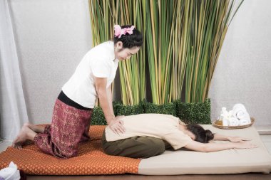 Tayland Masözü spa salonundaki kadına masaj yapıyor. Tayland masajı yaptıran Asyalı güzel kadın spa 'da masaj yaptırıyor. Çok rahat. Sağlıklı Konsept