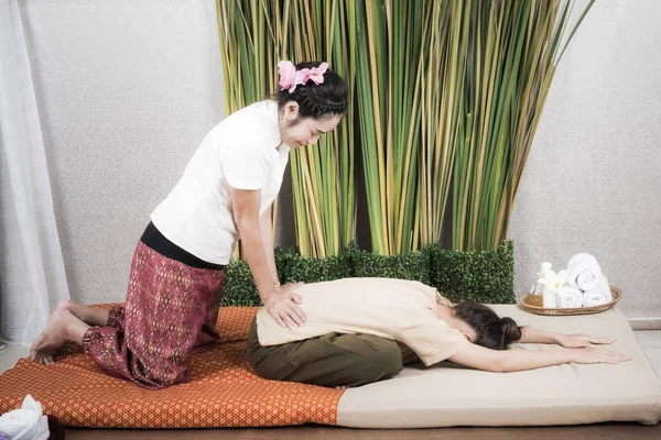 Thai Masseuse gör massage för kvinna i spa salong. Asiatisk vacker kvinna få thai växtbaserade massage kompress massage i spa.She är mycket avslappnad. Friska koncept — Stockfoto