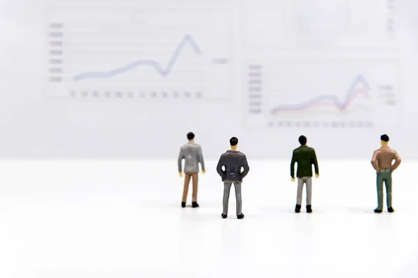 Miniature group businessman view the financial graph on the board and thinking with project for presenting investment.  Investment and Business Concept. select focus — Stock Photo, Image