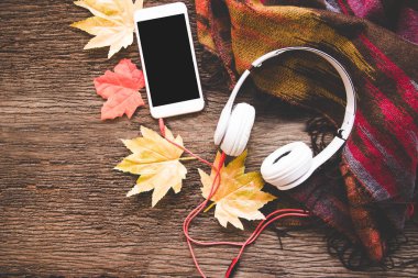 Sıcacık kış arka plan, hatmi ve kulaklık müzik, akıllı telefon, sıcak örme kazak, vintage sesi ile sıcak kahve. Yaşam tarzı ve müzik konsepti