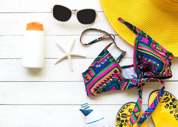 Estate Moda donna giallo grande cappello e accessori in spiaggia. Mare tropicale.Vista dall'alto insolita, fondo bianco legno. Concetto estivo . — Foto Stock