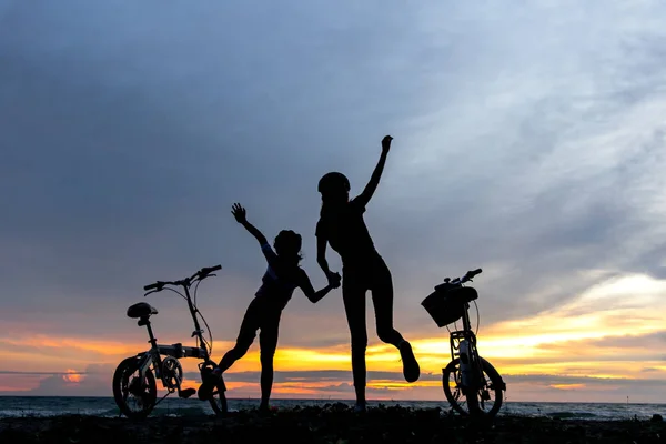 실루엣 자유 자전거 사랑 스러운 가족 바다 석양. 자매 해변에서 자전거입니다. 라이프 스타일 개념. — 스톡 사진