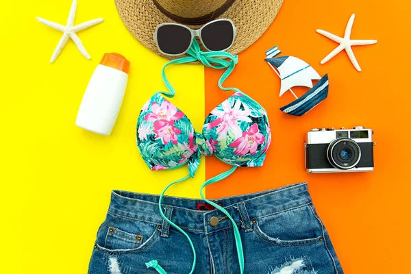 Nyári divat nő fürdőruha Bikini. Trópusi utazás a tenger. Szokatlan felülnézet, színes, sárga és narancssárga háttérrel. Nyári & utazási koncepció. — Stock Fotó