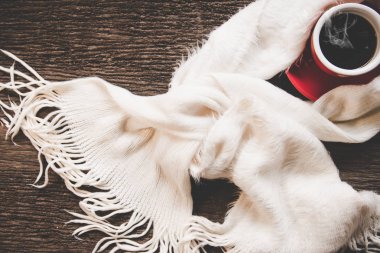 Sıcacık kış arka plan, hatmi, eski ahşap zemin, vintage sesi üzerine sıcak örme kazak ile sıcak kahve. Yaşam tarzı kavramı