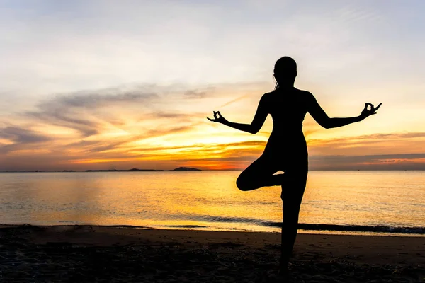 Meditation yoga lifestyle woman silhouette on the Sea sunset, relax vital.  Healthy Concept