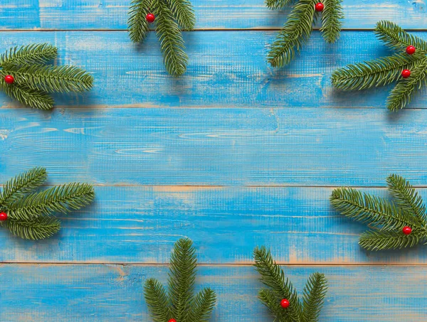 Christmas frame made of fir branches, red berries. Christmas wallpaper, copy space.  Holiday Concept
