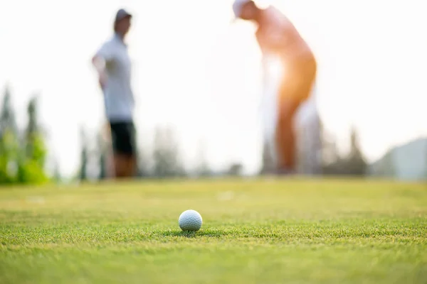 緑保留へゴルフ ボールのアプローチ カップルでゴルフ プレーヤー置くゴルフボール バック グラウンドで ライフ スタイルのコンセプト — ストック写真