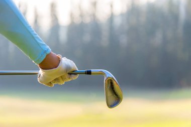 Bir golf kulübü golf sahası içinde tutan golf oyuncusu kadın. Yaşam tarzı kavramı