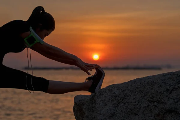 健康的亚洲女子运动员伸展腿热身前运行在公园日落 健康和生活方式概念 — 图库照片