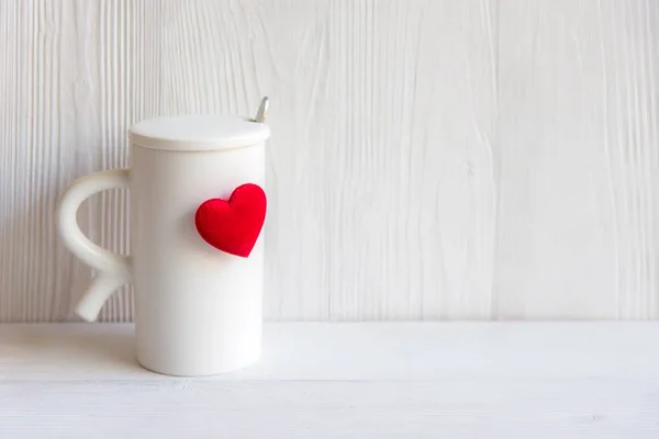 Valentine\'s Day with white cup coffee red heart on the cup, wood white background.  Valentine Concept.