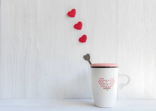Valentine\'s Day with white cup coffee red heart row on the cup, wood white background, copy space  Valentine Concept.