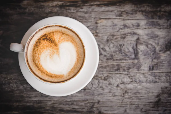 Kahve kalp bir beyaz daire, eski ahşap arka plan, vintage sesi ile. Sevgililer kavramı