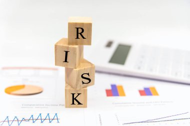 İş yatırımında risk. Kağıt üzerinde kelime riski beyaz, finansal grafiği analiz eder. Yatırım Kavramı.