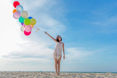 Yaşam tarzı Asyalı kadın el balon sahilde tutarak gülümseyerek. Sakin ve yaz tatil keyfini çıkarın. Yaz ve seyahat Concep