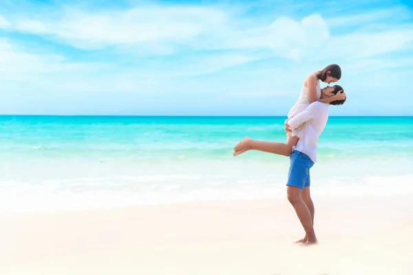 热恋中的情侣微笑的亚洲青年男子抱着女朋友在他的怀里在海滩上的晚上 蓝色的天空心形背景 蜜月在夏季旅行中一起放松 情人节 旅游和夏季概念 — 图库照片