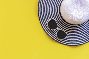 ummer moda kadın büyük şapka ve plaj aksesuarları. Tropikal deniz. Olağandışı üstten görünüm, sarı arka plan. Yaz konsepti.