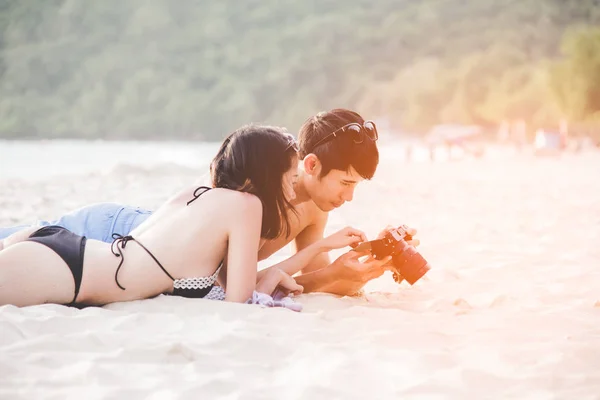 夫妇享受和快乐的乐趣 在海滩上笑着一起看暑假旅游照片图片复古相机 蜜月放松 情人节旅行目的地和舒适 — 图库照片