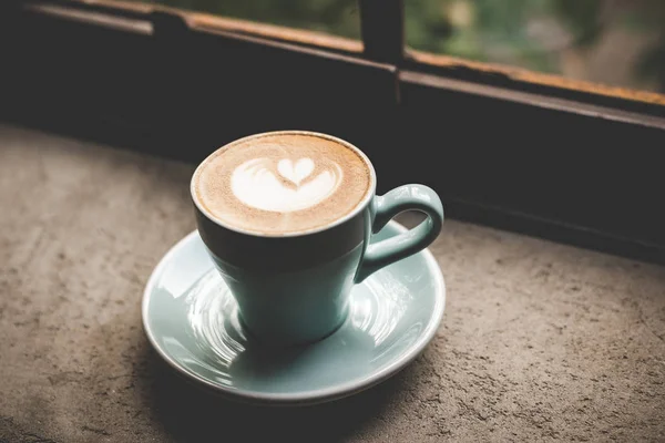 Valentine day.  Shape heart on the cup of coffee on the old wood near the window, vintage tone.  Valentine Concept.