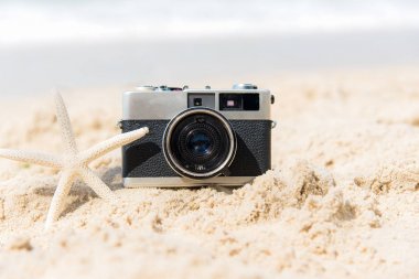 Yaz tatillerini. Turizm yıldız balık ile kum plajındaki Vintage eski fotoğraf makinesi. Seyahat kavramı arka plan.