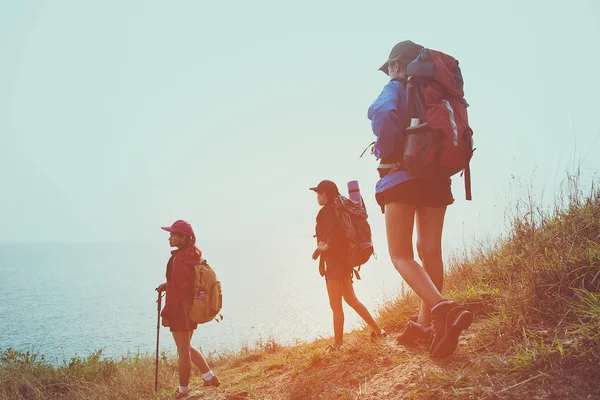 在日落时分 一群徒步旅行者带着背包走在山上的年轻女子 旅行者去野营 旅游理念 — 图库照片