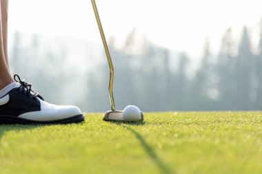 Golf oyuncu kadınlara yeşil koyarak tatil güneşli bir günde bir deliğe topa vuruyor. Yaşam tarzı kavramı
