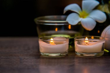 Tay spa kompozisyon tedaviler aroma terapi mumlar ve ahşap masaya Plumeria çiçek ile kapatın. Sağlıklı kavramı