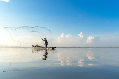 Ne zaman güneş sabah, güzel mavi gökyüzü arka plan Balık ağı göl kenarında balıkçı eylem. Tayland