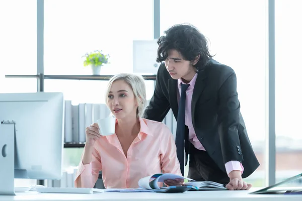 Business team women and man using computer to work with financial data. Partners discussing graph of report growth.  People women drinking coffee and working her job in modern office. Business Concept.