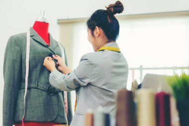 Asyalı genç kadın moda tasarımcısı showroom onu tasarımcı üzerinde çalışan, Lifestyle Şık terzi stüdyoda manken ölçümleri alarak. İş küçük Kavramı