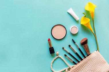  Makyaj malzemeleri ve güzellik kozmetik hediyeleri, ürünler ve yüz kozmetik paketleri mavi arka planda sarı zambak çiçekli ruj, üst manzara ve kopyalama alanı. Yaşam Tarzı Güzellik Konsepti