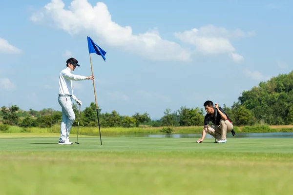 아시아 남자와 친구가 코스에서 구멍에 넣었다는 이유로 있습니다 골프에서 휴가를 — 스톡 사진