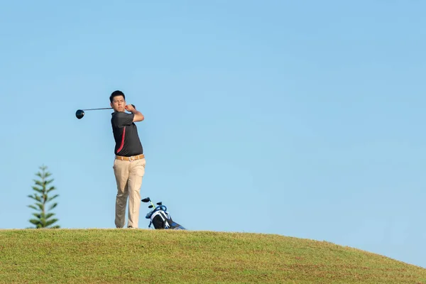 선수인 아시아 남자가 스윙을 골프공을 웨이를 오프에 휴일에는 취미로 아침에는 — 스톡 사진