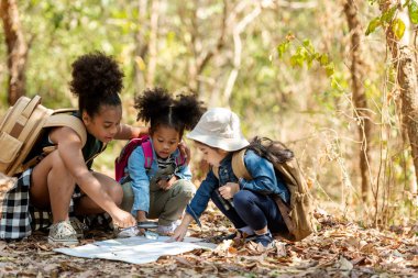 Grup aile çocukları haritada keşfe çıkıyor ve kamp ormanı doğası ve macerası hakkında bir yol buluyor. Turizm çocukları eğitim ve tatil gezileri için seyahat eder ve doğa parkında dinlenirler. Seyahat Konsepti