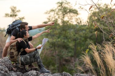 Yürüyüş çifti sırt çantasını göstererek ve oturarak özgürlüğünü hissederek doğal dağda zaferle karşılaşıyor. Gezgin kamp yapmaya gidiyor.