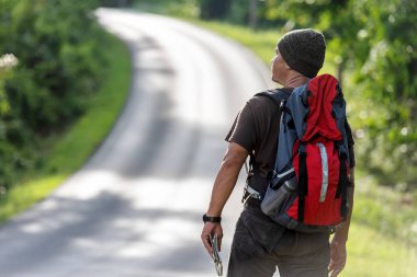 Sırt çantasıyla gezen Asyalı turist ve gezgin, orman ormanı ve eğitim için açık havada yol ve keşif haritası tutuyor. Seyahat ve Seyahat Konsepti